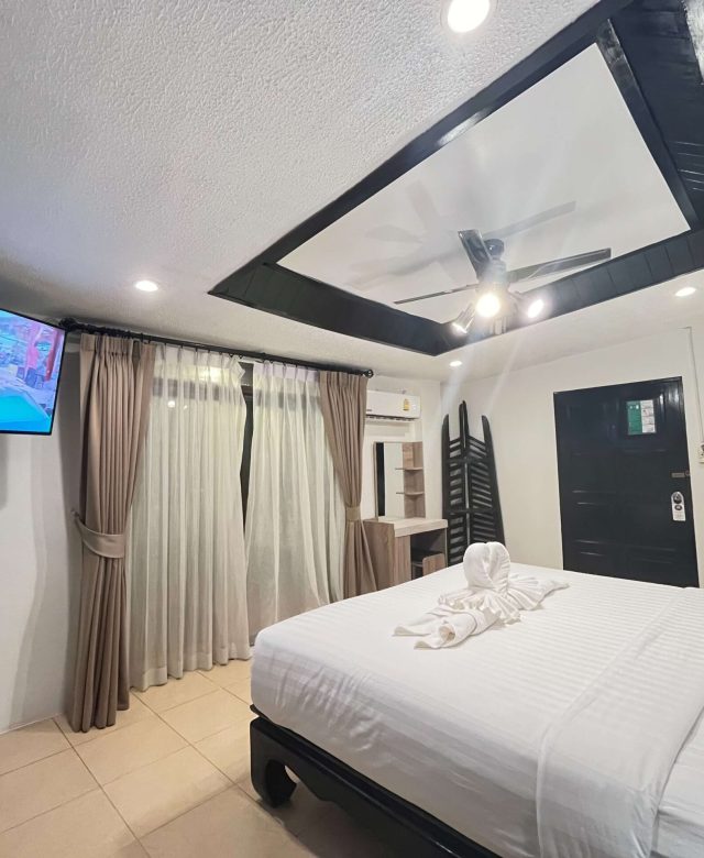 Family Room with queen bed, TV, sheer curtains, heart towel art, black accent wall — 1 min to beach, 5 min to Bangla Road.